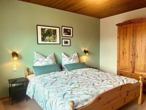 a bedroom with a large bed with a wooden ceiling at Pension 1595 im Weingut Botzet in Maring-Noviand