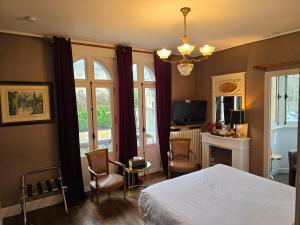 1 dormitorio con 1 cama, mesa y sillas en Le Castel Guesthouse, en Bayeux