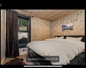 ein Schlafzimmer mit einem Bett in einem Zimmer mit einem Fenster in der Unterkunft Flott moderne hytte i Holterdalen, 4 soverom, 2 bad, Jacuzzi, garasje in Rauland