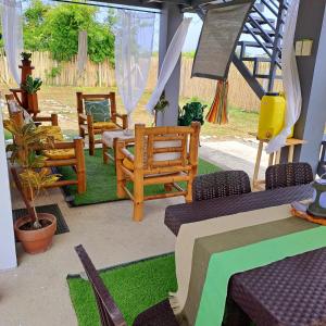 un patio con un mucchio di sedie e un tavolo di The Beaulah Overlooking Cozy Hideaway in Hundred Islands a Alaminos
