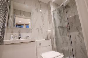 a bathroom with a shower and a toilet and a sink at The Avonmore Olympia in London