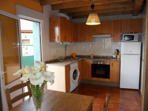 a kitchen with a table with a vase of flowers on it at Casa Pepe El Segador - VV-1054-AS in San Juan de la Arena