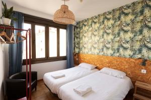 una camera d'albergo con due letti e una sedia di Green Hostel Oviedo a Oviedo