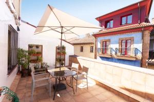 a patio with a table and an umbrella on a balcony at Green Hostel Oviedo in Oviedo