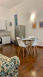 a living room with a table and chairs and a kitchen at Mary Shelley - elegant 2 bedrooms with balcony in La Spezia