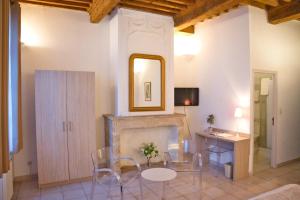 een woonkamer met een tafel en stoelen en een spiegel bij La Taverne in Uzès