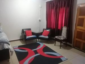 a living room with two chairs and a rug at GLORIA'S GUESTS.COM in Polokwane