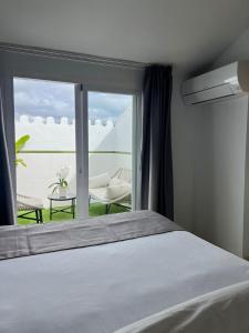 - une chambre avec un lit et une vue sur une terrasse dans l'établissement Abril Nerja, à Nerja