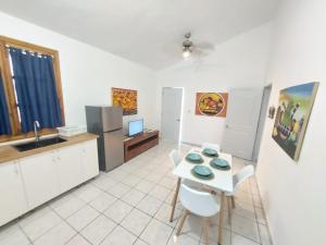 uma cozinha com uma mesa e cadeiras e um lavatório em Sueño caribeño em La Laguna