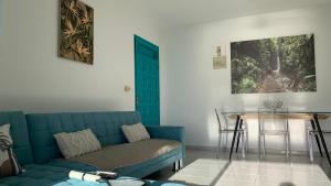 un soggiorno con un divano blu e un tavolo di Appartement Ciel et Mer a Schœlcher