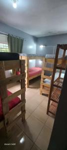 a room with three bunk beds and a staircase at Hostel CAMI in Erechim