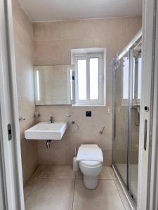 a bathroom with a toilet and a sink and a shower at Sunshine Court Apartment No 1 in Sliema