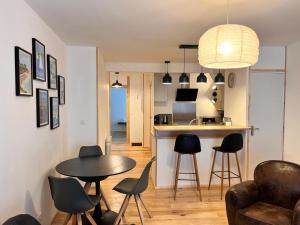 uma cozinha e uma sala de estar com mesa e cadeiras em Appartement à Valognes : Entre Terre et Mer em Valognes