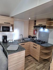 une cuisine avec un évier et un plan de travail dans l'établissement Mobil-home camping Mar Estang, à Canet