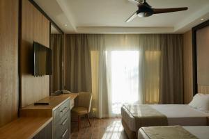 a hotel room with two beds and a desk and a window at Panorama Naama Heights in Sharm El Sheikh
