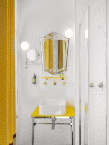 La salle de bains est pourvue d'un lavabo et d'un miroir. dans l'établissement Hôtel Crayon Rouge, à Paris