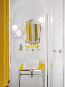 a bathroom with a sink and a mirror at Hôtel Crayon Rouge in Paris