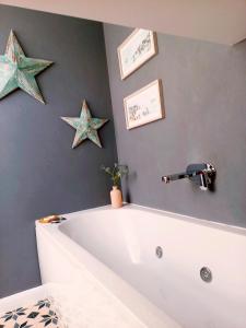 a bath tub in a bathroom with stars on the wall at Englefield Guesthouse in Goathland