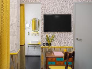 a living room with a television on a wall at Hôtel Crayon Rouge in Paris