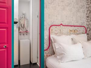 a bedroom with a red door and a bed with white pillows at Hôtel Crayon Rouge in Paris