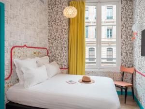 a bedroom with a bed with a hat on it at Hôtel Crayon Rouge in Paris