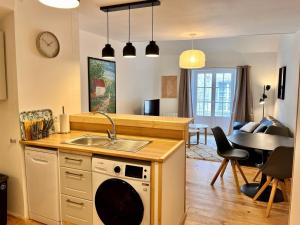 uma cozinha e sala de estar com um lavatório e uma máquina de lavar louça em Appartement à Valognes : Entre Terre et Mer em Valognes