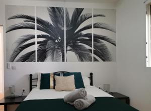 a bedroom with a large palm tree painting on the wall at Vilalea - Maison de vacances 8 pers in Petit-Bourg +15 photos