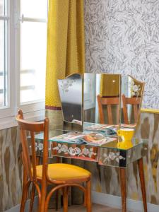 a dressing table with a mirror and a chair at Hôtel Crayon Rouge in Paris