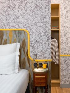 a bedroom with a bed and a side table with a mirror at Hôtel Crayon Rouge in Paris