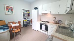 - une cuisine avec des placards blancs, un évier et une table dans l'établissement RomagnaBNB Colonna, à Bertinoro