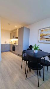 una sala da pranzo con tavolo e sedie e una cucina di Towergate Apartment 13 a Buckinghamshire