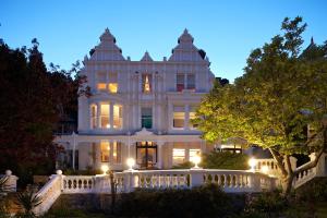 a large white house with a porch at night at Escape Boutique B&B in Llandudno