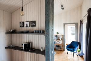 a living room with a blue chair and shelves at Ganu Māja in Užava