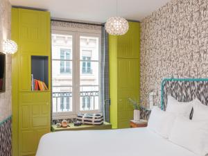 a bedroom with green and yellow walls and a bed at Hôtel Crayon Rouge in Paris