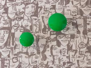 a green ball in front of a crowd of faces at Hôtel Crayon Rouge in Paris