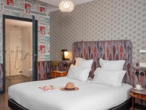 a bedroom with a bed with a hat on it at Hôtel Crayon Rouge in Paris