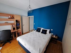 a blue bedroom with a large bed and a desk at Lapartments 43 in Ioannina