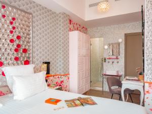 a bedroom with a bed and a bathroom at Hôtel Crayon Rouge in Paris