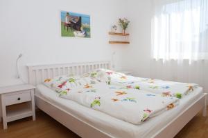 a bed with a white blanket with butterflies on it at FeWo Bayha "Im Ort" in Langenargen