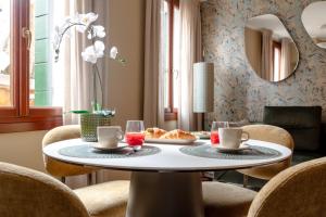 a dining room with a table and chairs and a mirror at Venice Suite San Marco 213 in Venice