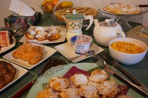 una mesa con muchos pasteles y otros productos para el desayuno en B&B Locanda Montefabbri, en Monte Fabbri