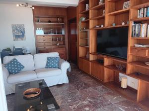 uma sala de estar com um sofá branco e uma televisão em Alojamiento Iberia Playa em Estepona