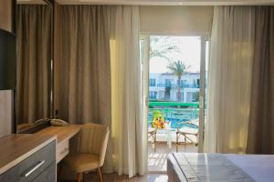 een hotelkamer met een bureau en uitzicht op een patio bij Panorama Naama Heights in Sharm El Sheikh