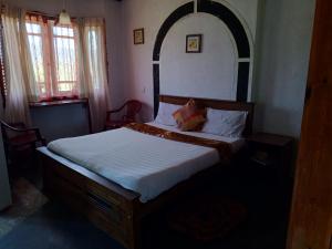 um quarto com uma cama grande e um arco por cima. em Mount View Cottage em Nuwara Eliya