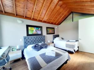 a bedroom with two beds and a desk at Lodge in Guatapé, Cottage on the Lake with Jacuzzi in Guatapé