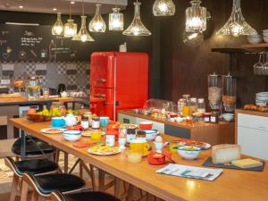 a kitchen with a table with food and a red refrigerator at Hôtel Crayon Rouge in Paris