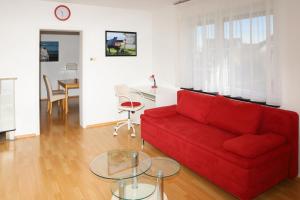 a living room with a red couch and a table at FeWo Bayha "Im Ort" in Langenargen