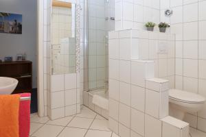 a white bathroom with a toilet and a shower at FeWo Bayha "Im Ort" in Langenargen +8 photos