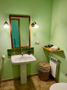 ein grünes Bad mit einem Waschbecken und einem Spiegel in der Unterkunft Can Pujol - Turismo Rural in Serra de Daró