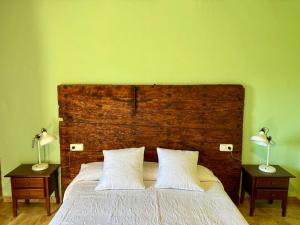 a bedroom with a large bed with two lamps on tables at Can Pujol - Turismo Rural in Serra de Daró